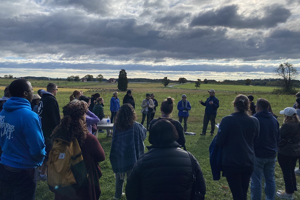 men and women of a corporate team stand on the Gettysburg battlefield for leadership presentation